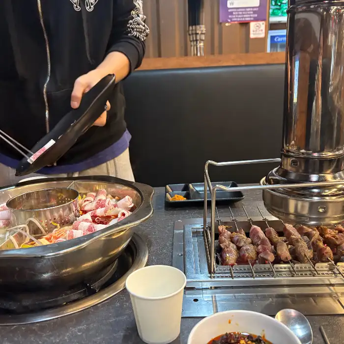 직원이 꼬치를 숯불에 올리는 모습