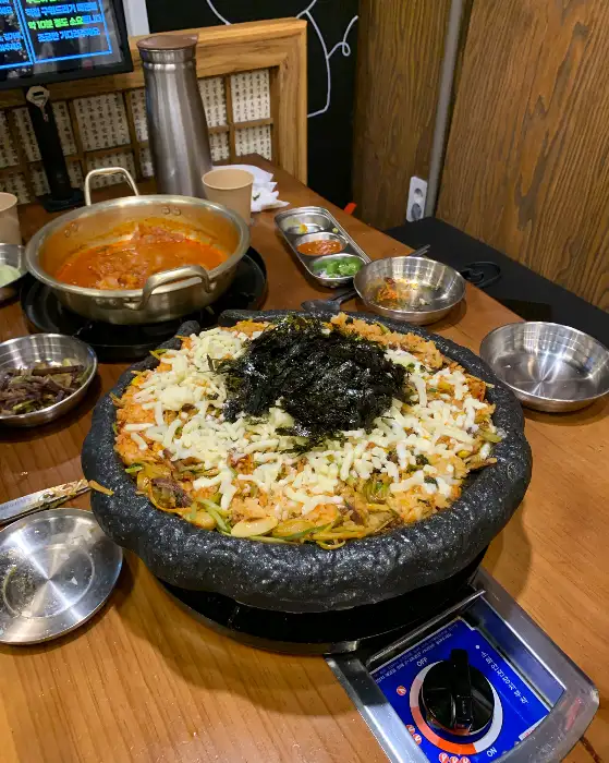 돌판 위에 볶음밥과 김가루, 치즈 등이 올라간 모습