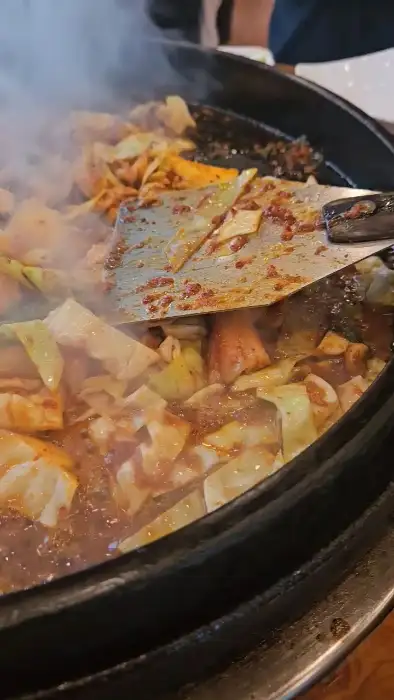 철판 위에서 볶아지고 있는 닭갈비와 채소