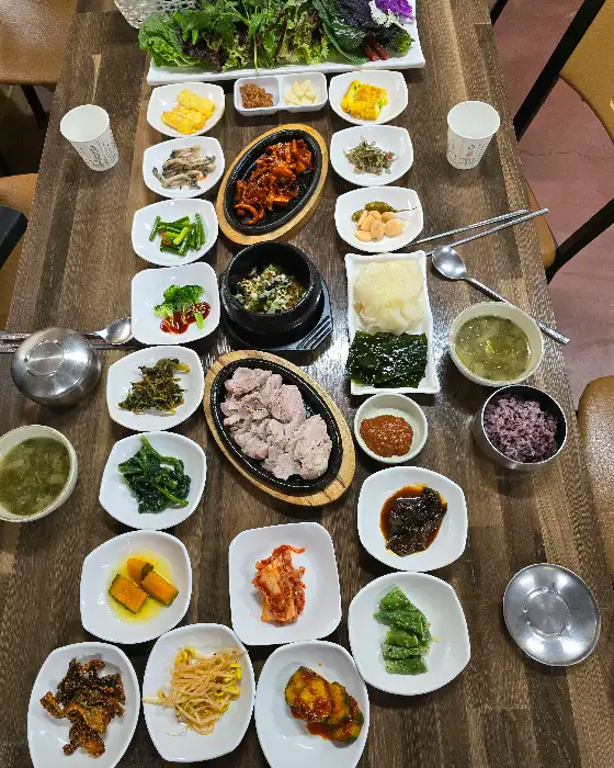 다양한 쌈 채소와 밑반찬, 메인 요리가 차려진 상차림