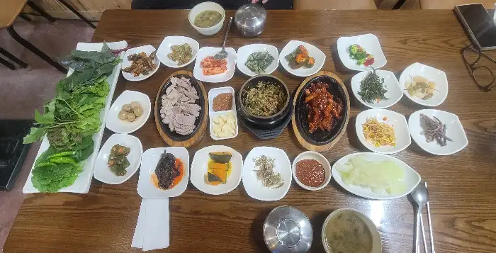 테이블에 정갈하게 차려진 다양한 쌈 채소와 반찬들