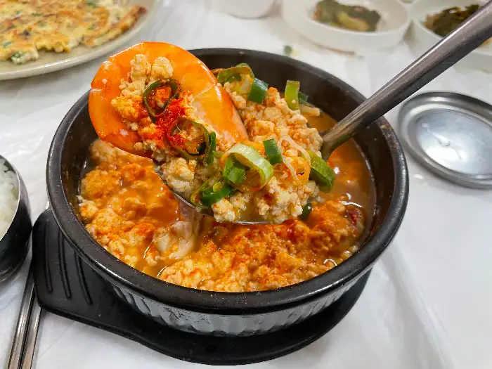 크고 신선한 새우 한 마리가 해물순두부 위에 올려져 있습니다.