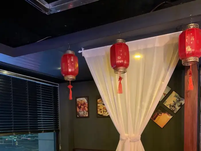 창가 쪽 테이블에 놓인 붉은 홍등과 커튼