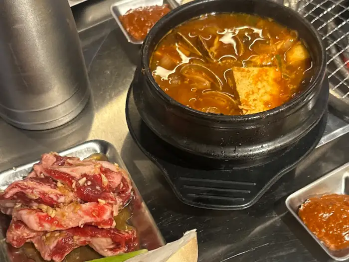 김치찌개와 신선한 고기가 함께 놓인 상차림