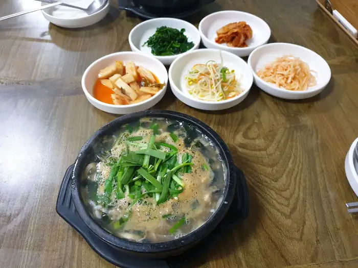 테이블에 놓인 굴국밥과 여러 반찬들