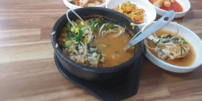 국자가 꽂힌 굴국밥과 몇 가지 반찬