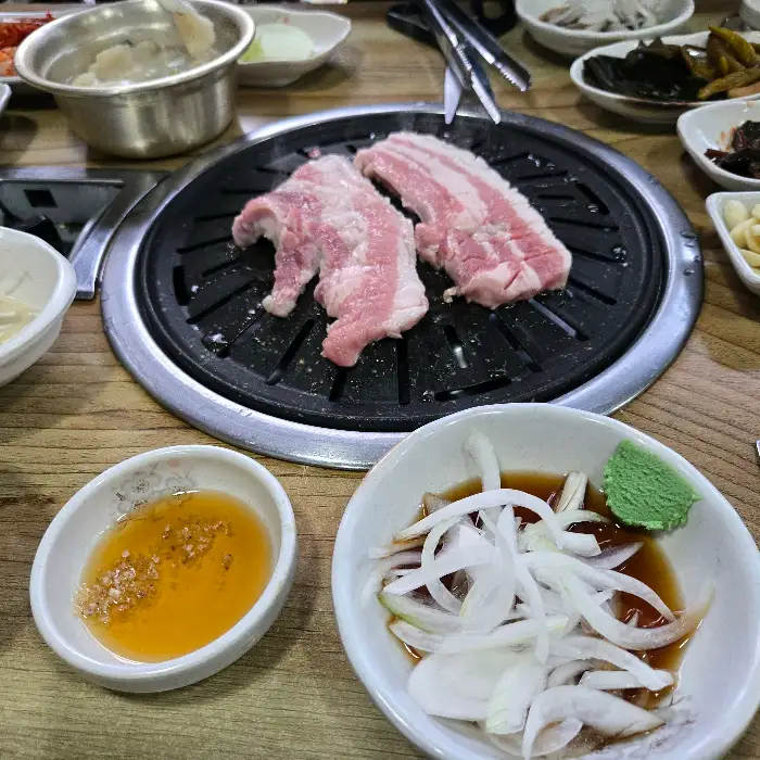불판 위에 구워지고 있는 두툼한 삼겹살