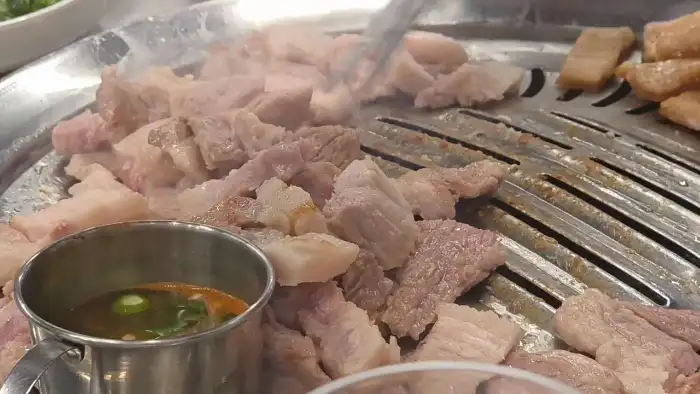직원분이 능숙하게 삼겹살을 굽는 모습
