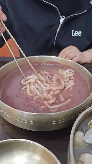 붉은 팥 국물에 담긴 칼국수 면발
