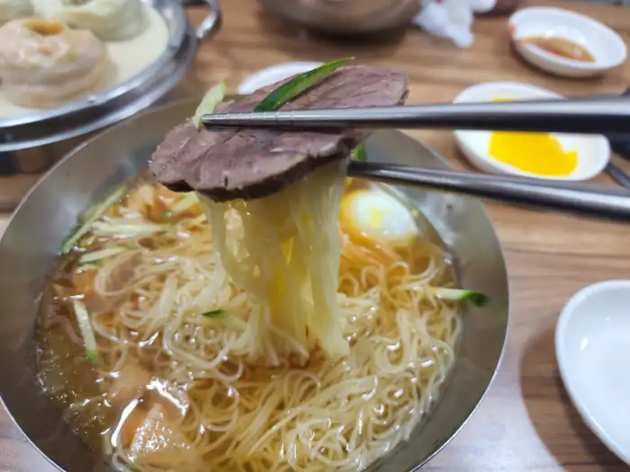 고기 조각과 함께 집어 올린 밀면
