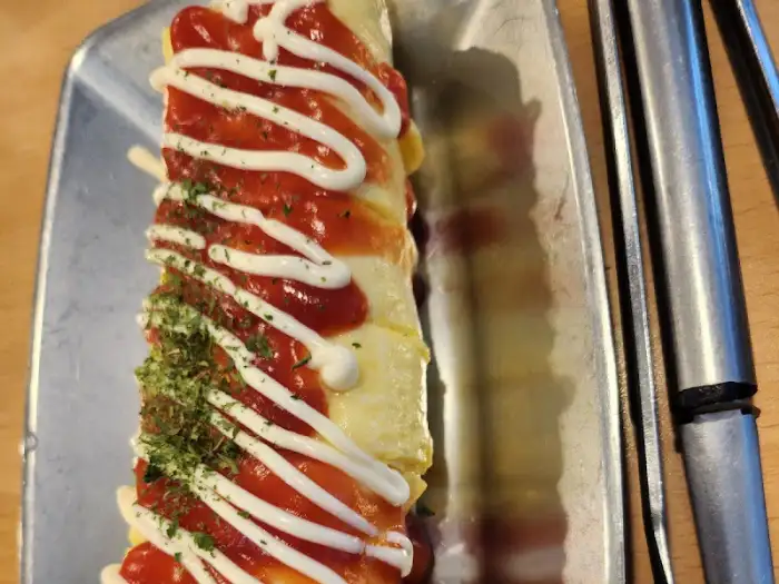 김치찌개 위에 얹어진 계란말이와 소스