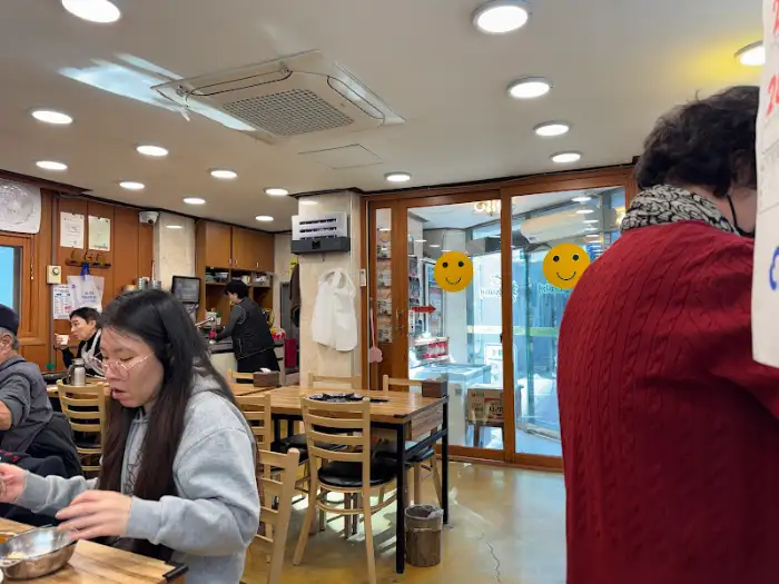 식당 내부의 테이블과 닫힌 유리문, 그리고 복도 모습