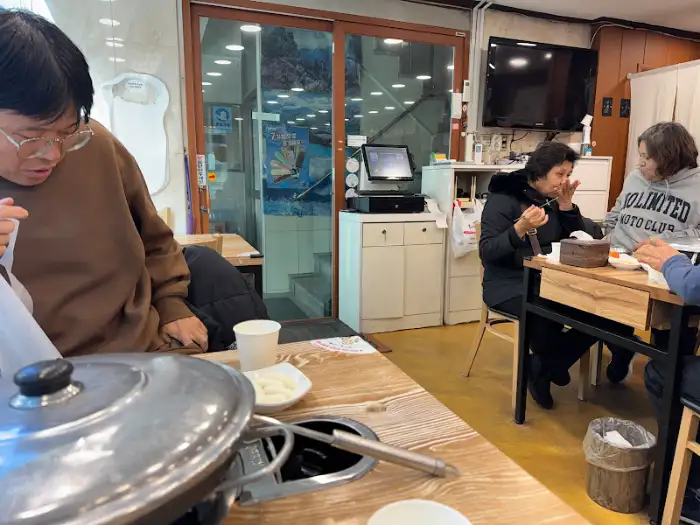 식탁 위의 냄비와 물컵, 그리고 손님들의 모습