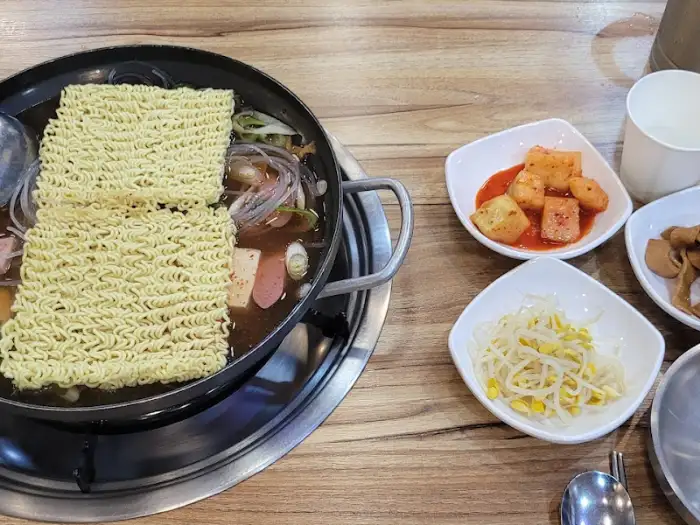 라면 사리가 듬뿍 올라간 부대찌개 냄비와 반찬