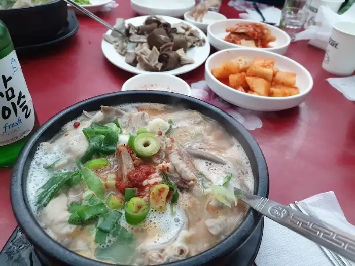 테이블에 놓인 순댓국과 다양한 밑반찬, 그리고 술병