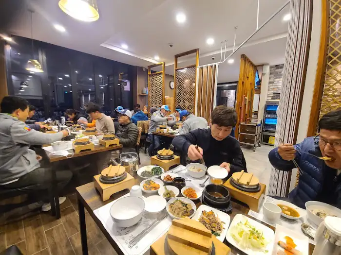 테이블에 둘러앉아 식사하는 사람들