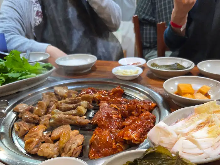 철판 위에서 익어가는 닭갈비와 곁들임 반찬들