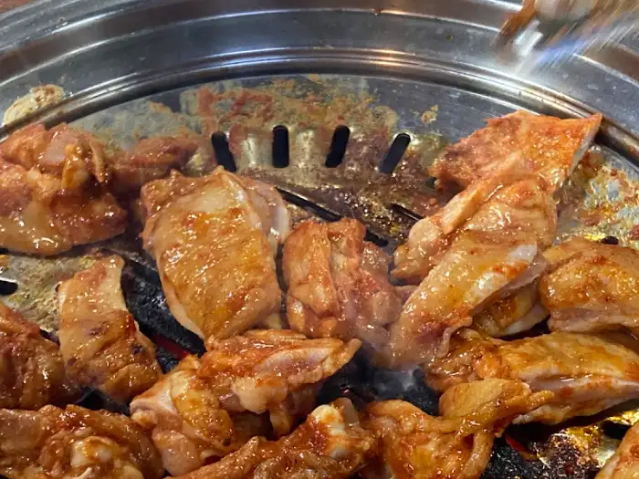 철판 위에서 지글지글 익고 있는 닭갈비 조각들
