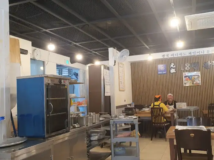 가게 내부의 전경, 테이블과 의자, 주방 일부가 보인다