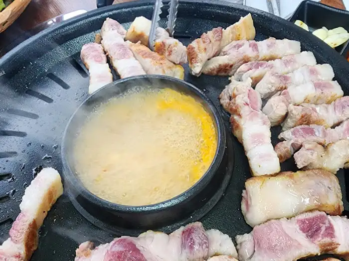불판 위에서 익어가는 삼겹살과 찌개