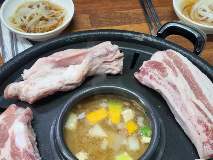 불판 위 삼겹살과 찌개 클로즈업