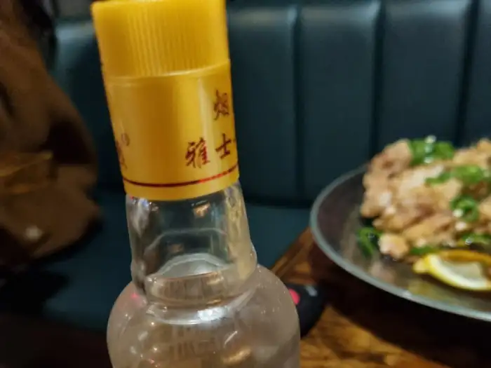 고량주 병 뚜껑과 뒷 배경의 요리