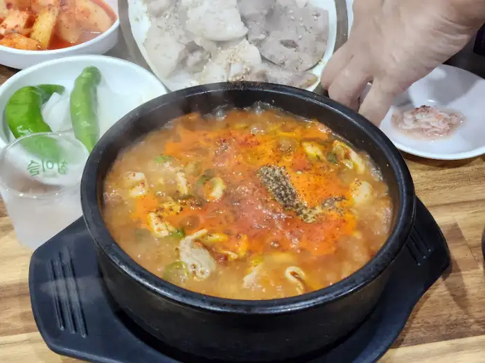끓고 있는 곱창 순대국과 곁들임 반찬