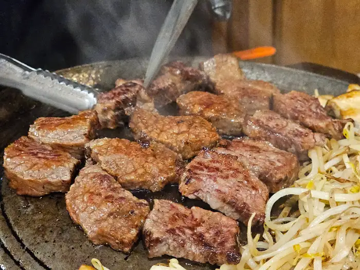 불판 위에서 맛있게 구워지는 우대갈비와 콩나물