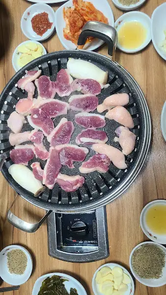 불판 위에 올려져 익고 있는 오리고기 조각들