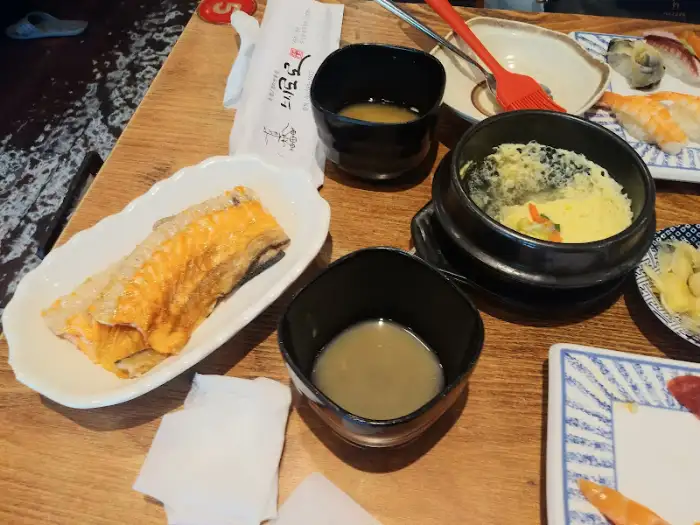 테이블에 놓인 음식과 식기류, 물컵 등의 모습