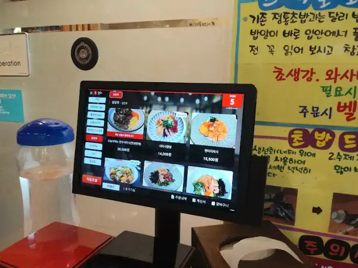 벽에 걸린 메뉴판과 키오스크 화면