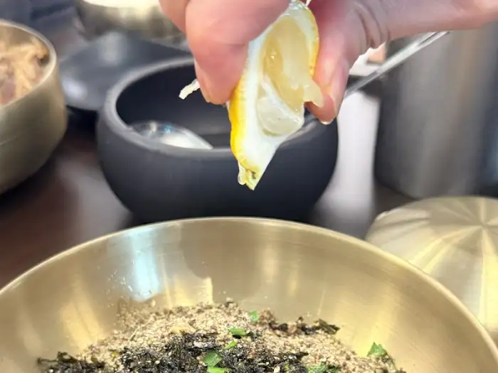창동 육개장 맛집 창동육칼의 들기름 막국수에 레몬즙을 짜는 모습