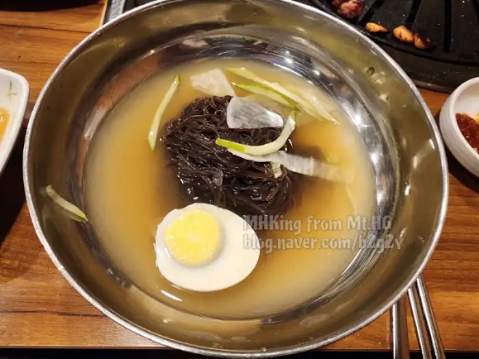 익은 뼈등심 조각이 숯불 위에서 먹음직스럽게 놓여 있는 모습