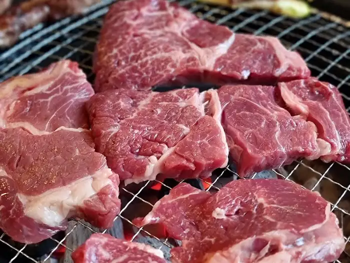 숯불 위에 다양한 부위의 날고기들이 놓여 있는 모습