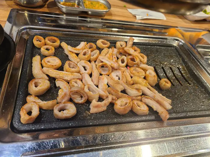 노릇하게 구워진 막창과 신선한 부추가 함께 놓인 모습. 막창의 고소함과 부추의 상큼함이 조화로운 한 상차림이다.