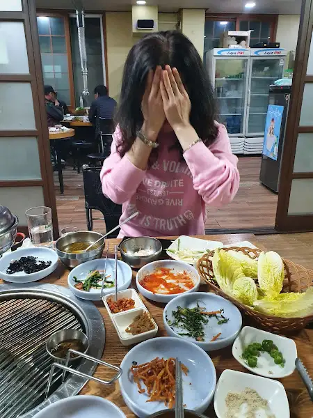 여인이 삼겹살을 앞에 두고 즐거워하는 모습