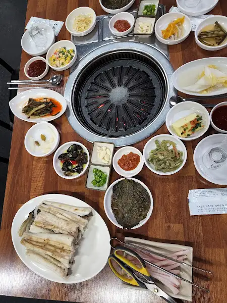 테이블 위에 차려진 다양한 음식과 불판