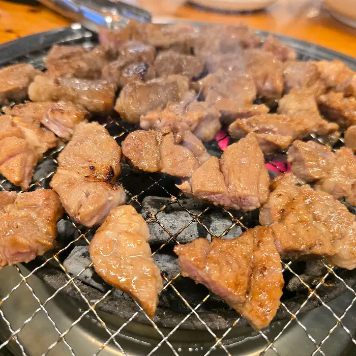 잘 익은 갈비가 불판에 가득 담겨 있습니다.
