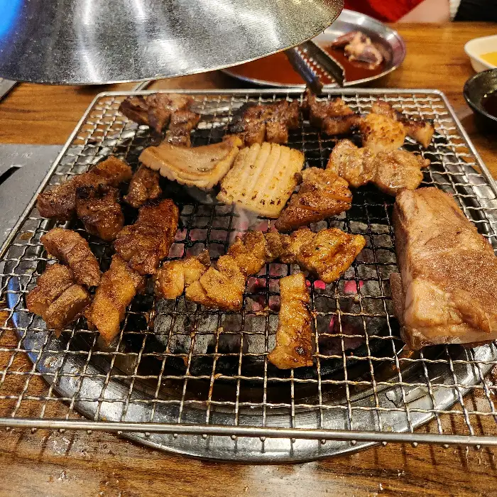 다양한 종류의 고기가 숯불 위에서 익어가고 있는 모습