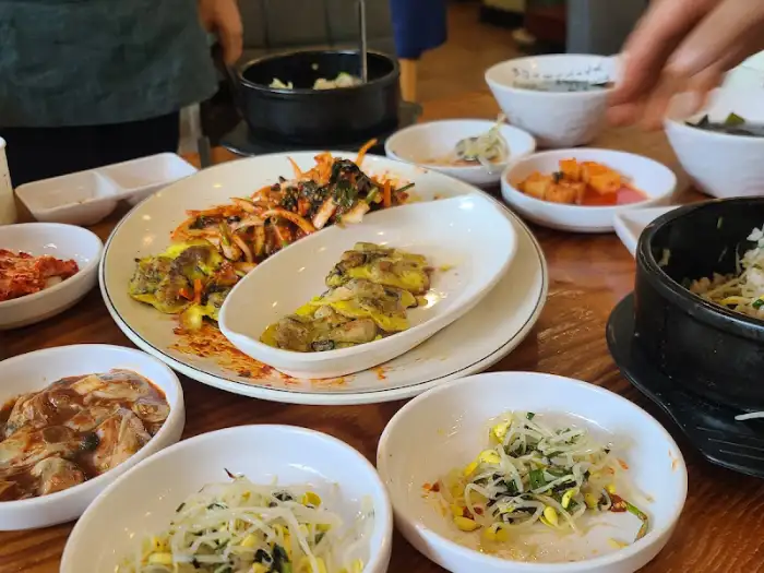 여러 접시에 담긴 음식과 숭늉처럼 보이는 국물