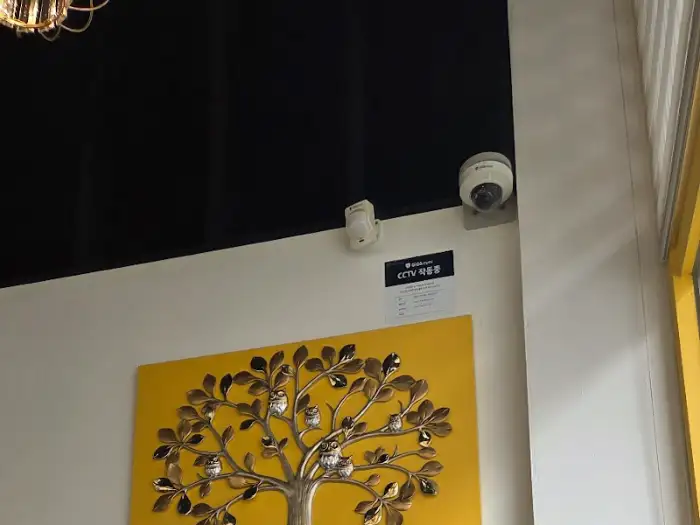 CCTV 안내문과 함께 장식된 액자가 걸려있는 벽면