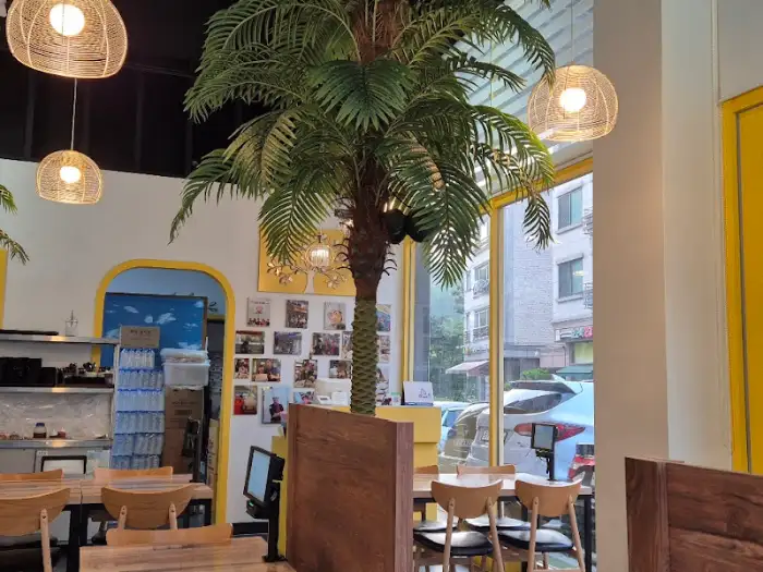 실내 중앙에 놓인 야자수와 함께 보이는 창밖 풍경