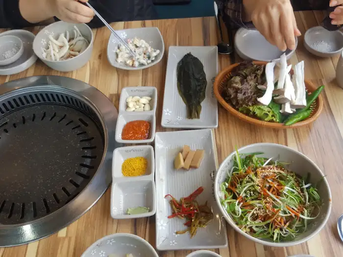 테이블 위에 놓인 반찬들과 쌈 채소, 그리고 쌈장