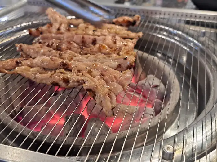 잘 익은 닭 목살이 숯불 위에서 먹음직스럽게 구워지고 있는 모습
