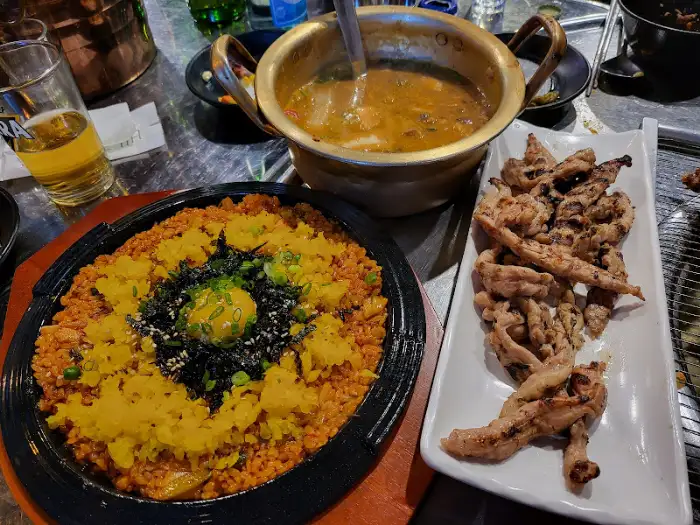푸짐하게 차려진 닭고기 구이, 장군밥, 그리고 파김치볶음밥의 전체 상차림