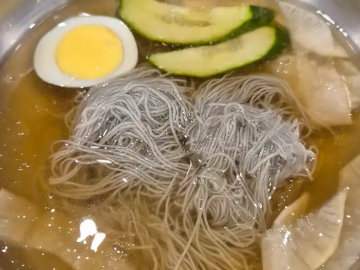 차가운 육수에 말아진 냉면. 얇고 쫄깃한 면발과 고명이 먹음직스럽다.