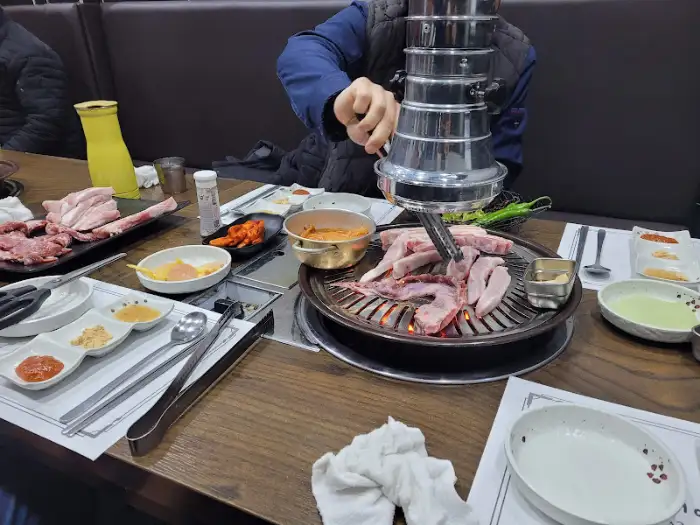 테이블 위에 차려진 다양한 밑반찬과 고기