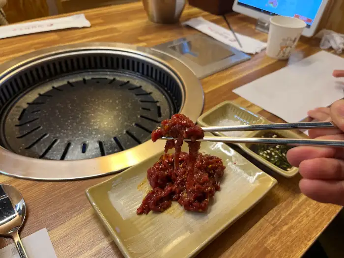 젓가락으로 집은 먹음직스러운 육회