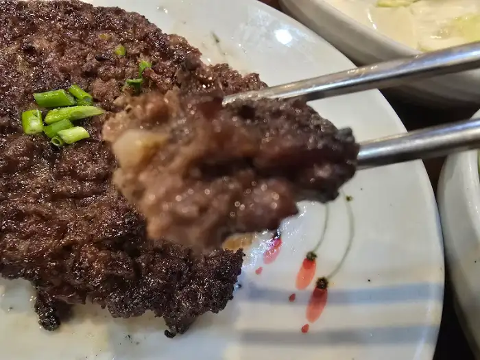젓가락으로 집어 올린 떡갈비 한 점