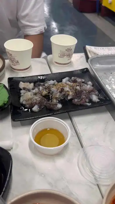 접시에 담겨 나온 생물 상태의 낙지 또는 오징어 같은 해산물